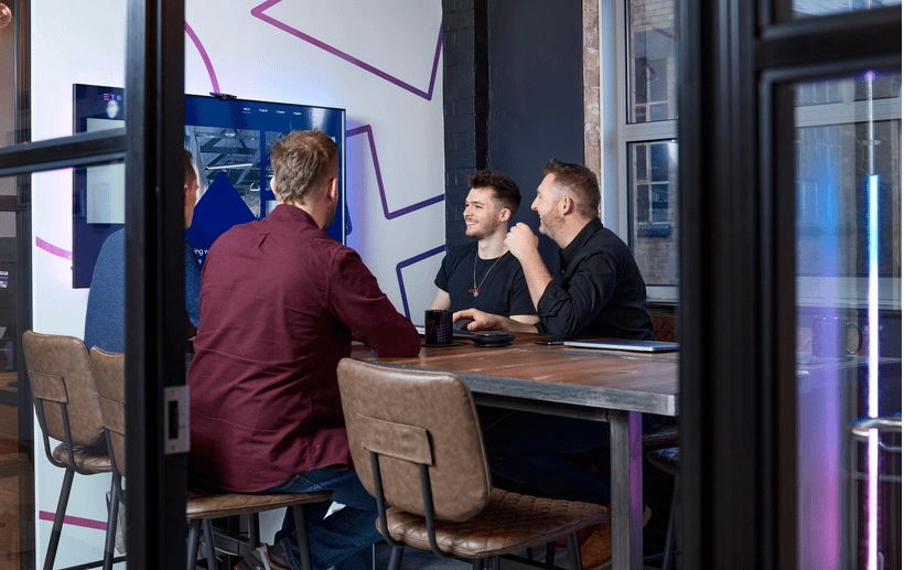 4 Evo Agency employees sitting at a table laughing